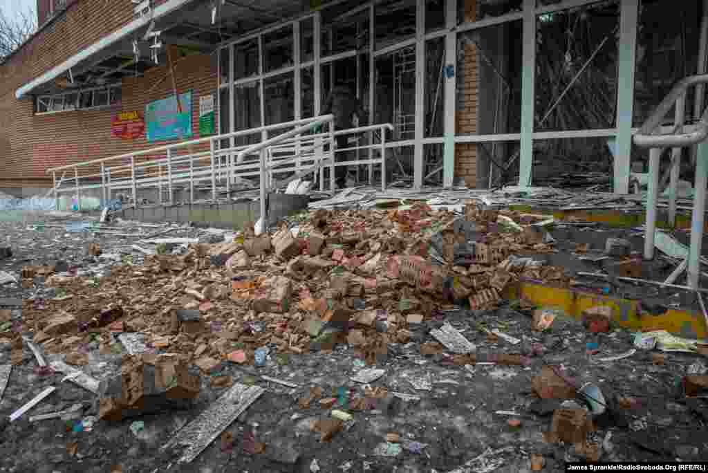 The entrance to the hospital, including a ramp for prams and wheelchairs, covered in rubble.