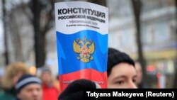 An opposition supporter holds a copy of the Russian Constitution during a rally against the reforms in Moscow on January 19.