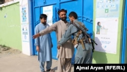 Afghan police check a voter who wanted to enter a voting center in Kunduz Province.