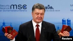 Ukraine's President Petro Poroshenko holds up Russian passports to prove the presence of Russian troops in Ukraine as he addresses the Munich Security Conference on February 7.