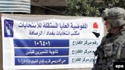 A U.S. soldier stands guard in front of a vote-counting center in Baghdad. Will Iraqi politicians be able to ensure security when he leaves?