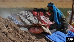 A member of the Kurdish People's Protection Units (YPG) fires toward Islamic State (IS) militants on the southern outskirts of the northeastern Syrian city of Hasakeh last week.