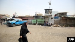 An Iraqi woman walks at the Oraiba market in Baghdad's Sadr City on May 12, 2016, a day after it was struck by a car-bomb attack.