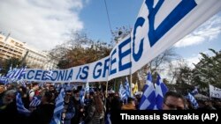 A banner reads "Macedonia is Greece" as demonstrators wave Greek flags during a rally in Athens on January 20.