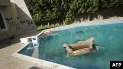 An armchair and furniture float in the swimming pool of the U.S. consulate in Benghazi following an attack on the building late on September 11, 2011, which resulted in the deaths of the U.S. ambassador to Libya, Chris Stevens, and three other US nationals.