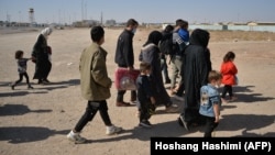 Afghans who were forcibly sent back to their country from Iran walk near the Islam Qala border crossing in the western Afghan province of Herat in October 2021.