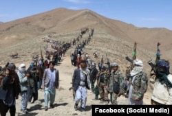 Zulfiqar Omid, a Hazara activist and politician (shown walking, left), on April 13 announced the creation of a “resistance front” in the province of Daikundi.