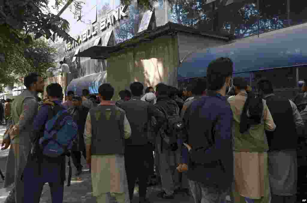 Afghans wait in front of Kabul Bank in long lines for hours to try to withdraw money.