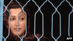 A prisoner looks out from a fenced window at the Female Detention Center in Kabul. (file photo)