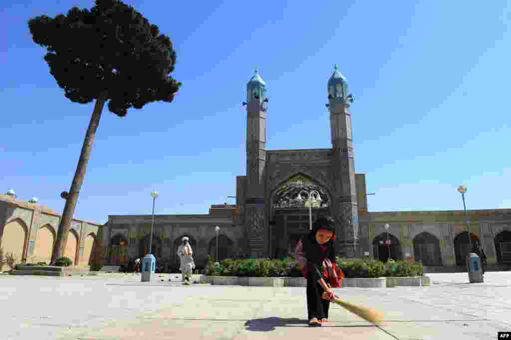 An Afghan girl sweeps at the main mosque in Herat ahead of the Islamic holy month of Ramadan. (AFP/Aref Karimi)