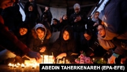 Iranians light candles for victims of the plane crash as they protest in front of Amir Kabir University in Tehran on January 11. 