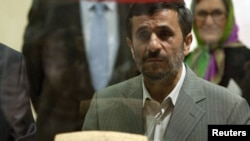 Iranian President Mahmud Ahmadinejad examines the Cyrus Cylinder at the National Museum in Tehran.