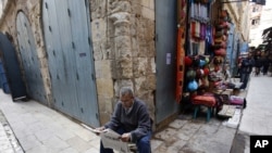 A man reads a newspaper on an empty street in the Khan el-Khalil district of Cairo on February 17, a week after President Hosni Mubarak stepped down.