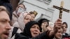 Believers pray while they block an entrance to a church on the compound of the Kyiv-Pechersk Lavra monastery in Kyiv on March 31.