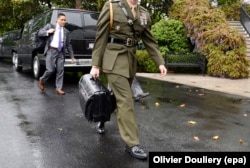 A military aide carries the nuclear football near the South Lawn of the White House in April 2017.