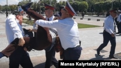 A protester is arrested in Almaty.