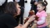 German Foreign Minister Annalena Baerbock gives a teddy bear to a girl as she visits ethnic Armenians who left Nagorno-Karabakh, outside Yerevan on November 4.