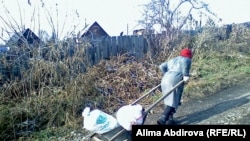 Woman hauls wheelbarrow in Zyryanovsk city eastern Kazakhstan