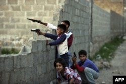 Pakistani children play with plastic guns in a street near Osama bin Laden's former hideout in Abbottabad in 2011.