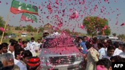 Pakistanis welcome the convoy of cricket star turned politician Imran Khan on his rally toward the tribal areas in Mianwali on October 6.