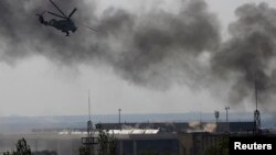 A Ukrainian Mi-24 helicopter gunship fires its cannons at rebels at the main terminal building of Donetsk's international airport on May 26.