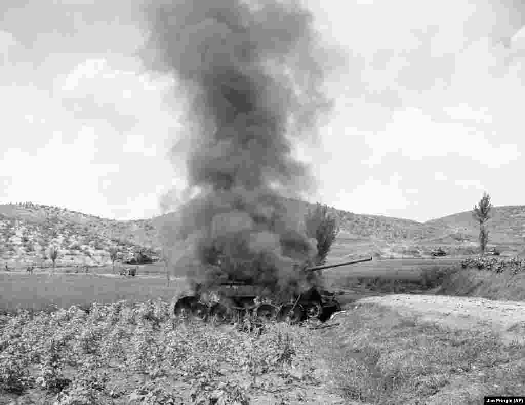 A Soviet-made North Korean T-34 on fire after being hit by an American tank during the Korean War, September 9, 1950.