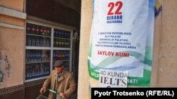 A shopper in Tashkent walks past a campaign poster for Uzbekistan's upcoming parliamentary elections on December 22. 