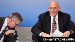 German Interior Minister Thomas de Maiziere (left) looks down beside of U.S. Secretary of Homeland Security John Kelly during a talk on the second day of the 53rd Munich Security Conference on February 18.