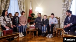 Qatar's ambassador to Russia (center) and the head of Russian president's Office of the Commissioner for Children's Rights meet with Ukrainian children and family members before their departure to Ukraine from Russia under a deal brokered by Qatar at its embassy in Moscow in December 2023.