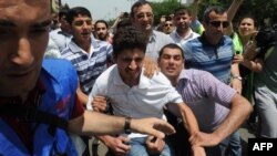 Plainclothes police officers detain opposition activists who tried to hold a rally near the public television station which is a partner for Eurovision broadcasts in Baku. (file photo)