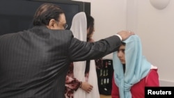 Pakistani President Asif Zardari greets Malala Yousafzai during his visit to the Queen Elizabeth Hospital in Birmingham on December 8.