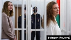 Katsyaryna Andreyeva (right) and Darya Chultsova stand inside the defendants' cage during the court hearing in Minsk on February 18.