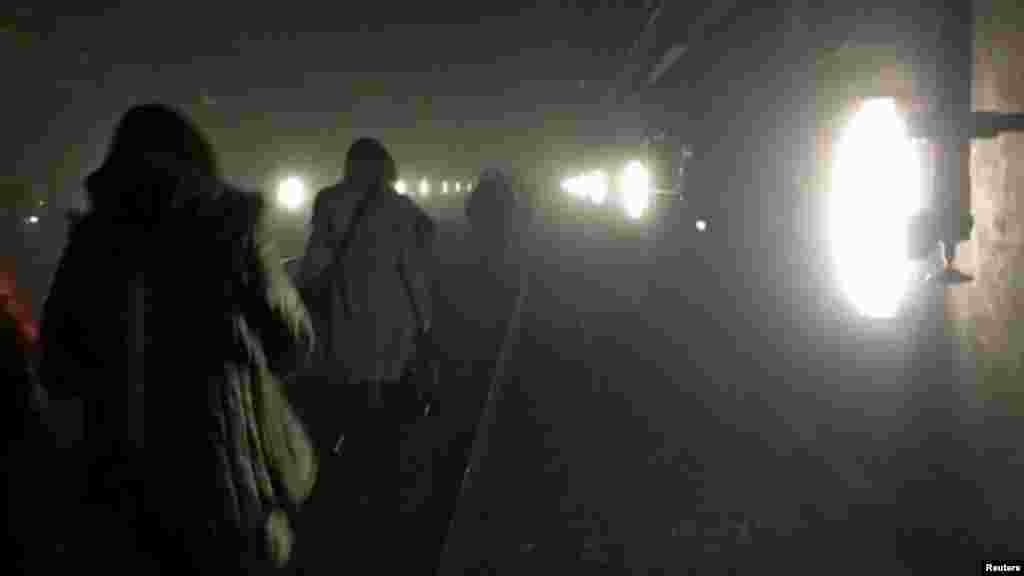 During the evacuation, passengers walk along the underground metro tracks.