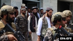 Anas Haqqani (center), the youngest son of Taliban co-founder Jalaluddin Haqqani, is escorted by Taliban fighters as he visits Hamid Karzai International Airport after the U.S. withdrawal in Kabul on August 31.