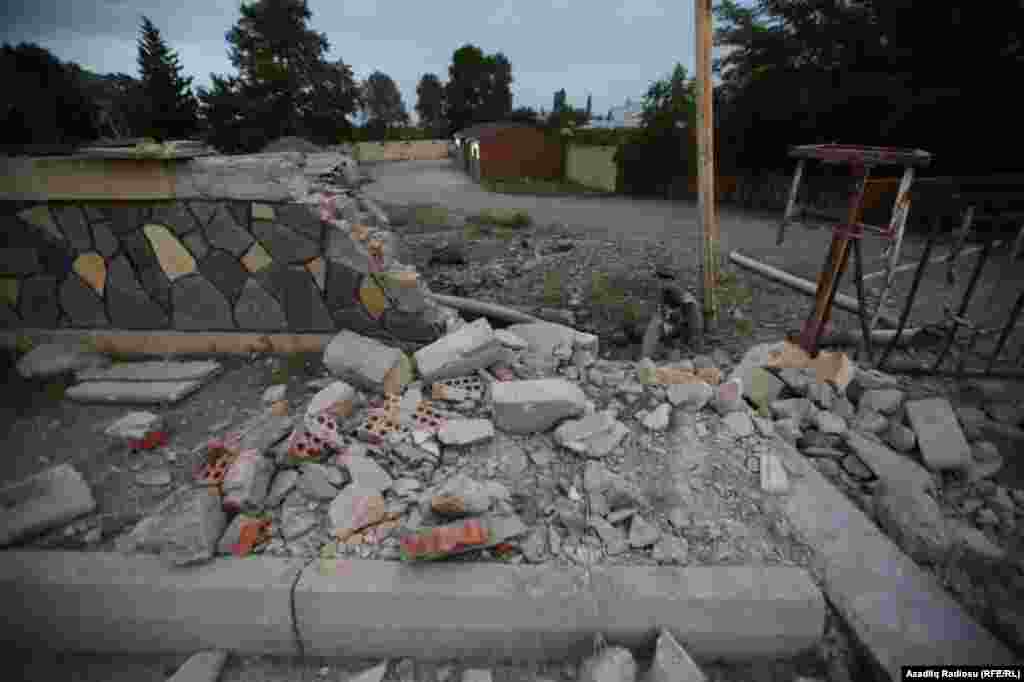 A damaged road and buildings in the Azerbaijani city of Tartar