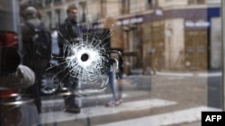 A bullet hole is shown on the window of a cafe located at the crossroads between the streets Saint-Augustin and Monsigny, where a man with a knife killed one man and wounded four other people. 