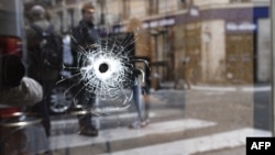 A bullet hole is seen on the window of a Paris cafe, near where Khamzat Azimov was shot dead after going on a knife rampage that killed one person and wounded four others. 