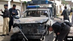 Police inspect the scene of a remote-controlled bomb blast in May 2010 that targeted a police vehicle in Dera Ismail Khan, the site of the most recent attack.