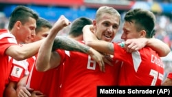 Russia's Yury Gazinsky celebrates with teammates after scoring his side's first goal during the group A match between Russia and Saudi Arabia.