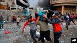 A wounded protester is carried away during clashes with security forces in Baghdad on November 28.