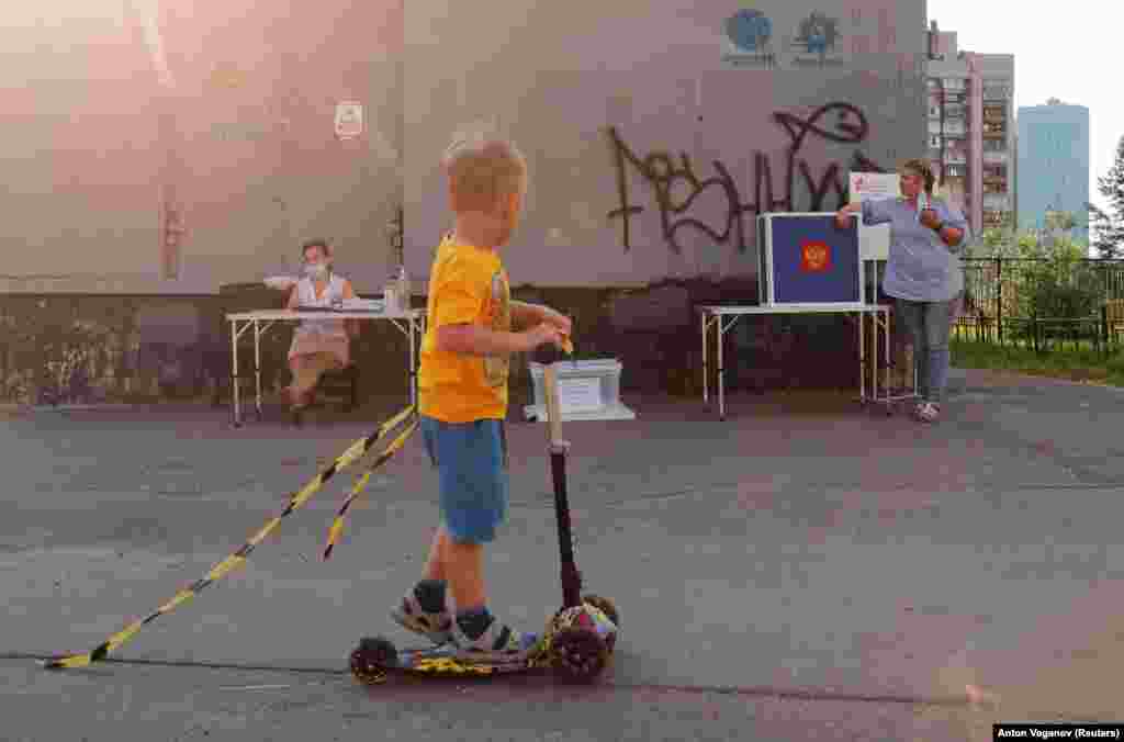 A boy rides his scooter past an outdoor polling station in St. Petersburg. Voting began on June 25 and is scheduled to last until July 1.