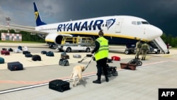 A Belarusian dog handler checks luggage from a Ryanair passenger jet, which made a forced landing at Minsk International Airport on May 23. Raman Pratasevich, a Belarusian journalist on board the flight, was subsequently arrested by the authorities. 