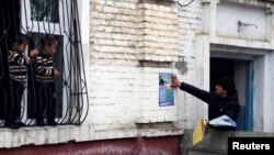 Tajik children watch a supporter of the Islamic Renaissance Party paste a campaign poster on a wall in the capital, Dushanbe, in February 2015. Within a few months it would be disbanded.