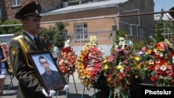 A soldier holds a picture of Vahe Avetian during the military doctor's funeral in Yerevan in 2012. 