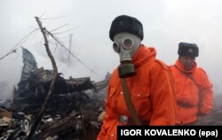 Rescuers wear protective gear while working at the crash site on January 16.