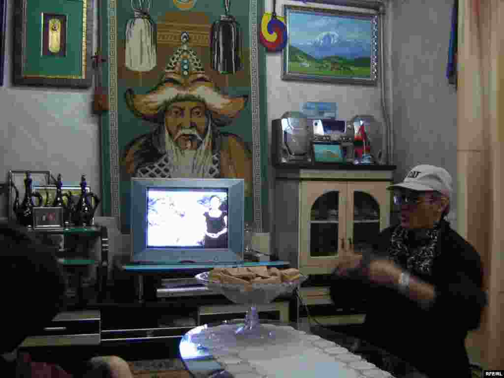 An image of Chinggis Khan adorns the wall of a private home in the village of Zuunkharaa. - Many Mongolian living rooms feature a must-have trinity of Chinggis Khan, a Buddhist shrine, and the obligatory bowl of aruul, or dried cheese curds.