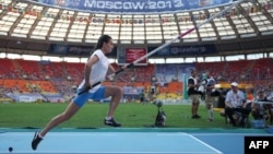 Russia's Yelena Isinbayeva won her third world pole-vaulting title at the World Athletics Championships in Moscow.