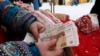 A meat vendor counts Russian rubles at an open-air food fair in Krasnoyarsk, Siberia.