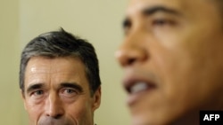 U.S. President Barack Obama (right) speaks to reporters as NATO Secretary-General Anders Fogh Rasmussen looks on during a meeting in the Oval Office of the White House.