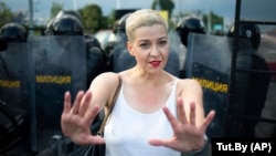 Maryya Kalesnikava, one of opposition presidential candidate Svyatlana Tsikhanouskaya’s top aides, gestures in front of riot police during the rally in Minsk on August 30.